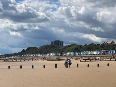a couple of people walking on the beach at 8 Bed Sun Decked Caravan Unlimited High speed Wifi and fun at Seawick Holiday Park in Clacton-on-Sea