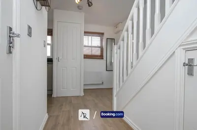 a hallway with white walls and a staircase with a door at Cozy House By AR Properties Short Lets & Serviced Accommodation Colchester in Colchester