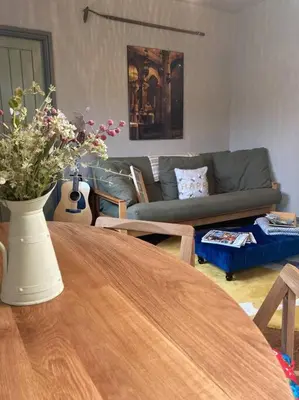 a living room with a wooden table with a vase of flowers at The BeeKeepers - Homely Luxurious Self Catering in Diss