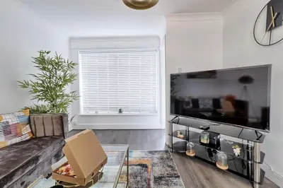 a living room with a couch and a tv at Stylish 3 bedroom House In Grt Gregorie Basildon & Essex - Free Wifi, Parking, Dedicated Office & Private Garden in Basildon