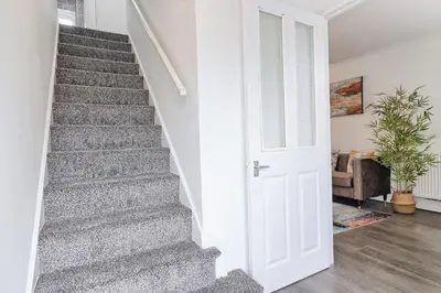 a staircase in a home with a white door at Stylish 3 bedroom House In Grt Gregorie Basildon & Essex - Free Wifi, Parking, Dedicated Office & Private Garden in Basildon