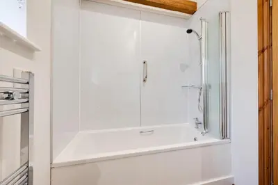 a white bathroom with a shower and a sink at 1 Bed in Quidenham oc-2233 in Quidenham