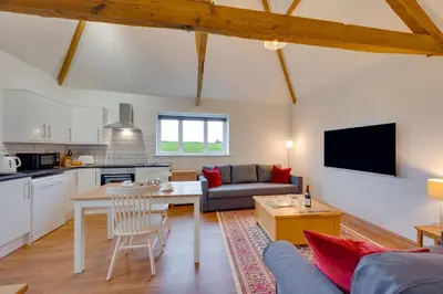 a kitchen and a living room with a couch and a table at 1 Bed in Quidenham oc-2232 in Quidenham