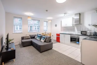 a living room with a couch and a kitchen at 1 Abbey Mews, Leiston in Leiston