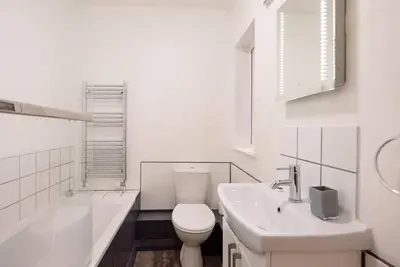 a white bathroom with a toilet and a sink at 1 Abbey Mews, Leiston in Leiston