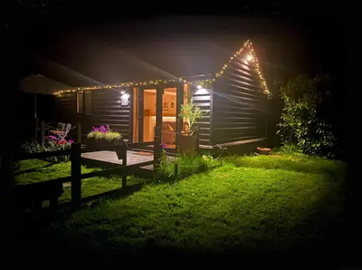 a house lit up at night with lights on it at The Little Barn in Hoxne