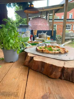 a pizza sitting on top of a wooden table at Frogmore Cottage in Leiston
