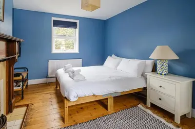a blue bedroom with a bed with a teddy bear on it at Frogmore Cottage in Leiston