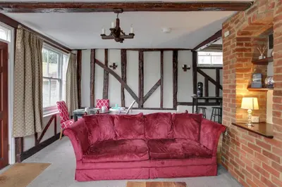 a living room with a red couch and a table at The Red House Maldon in Maldon