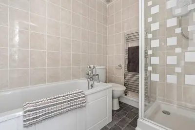 a bathroom with a tub and a toilet and a sink at Beach Front House in Walton-on-the-Naze