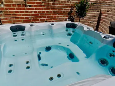 a jacuzzi tub in front of a brick wall at Huge Luxury 8 Bed Manor House Hot Tub Pool Table in Saffron Walden