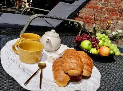 a plate of croissants and fruit on a table at Huge Luxury 8 Bed Manor House Hot Tub Pool Table in Saffron Walden