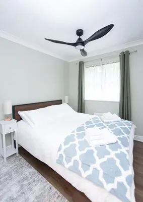 a bedroom with a bed and a ceiling fan at The Forest House in Brandon