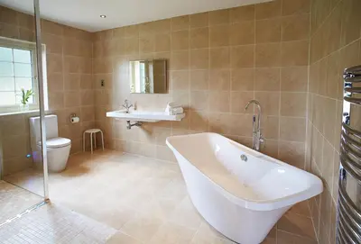 a bathroom with a tub and a sink and a toilet at Ramson Lodge in Chappel