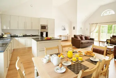 a kitchen and a living room with a table and chairs at Ramson Lodge in Chappel