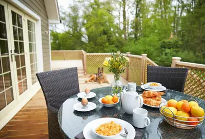a table with plates of food on a patio at Ramson Lodge in Chappel