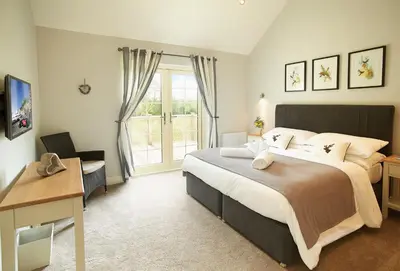 a bedroom with a large bed and a window at Ramson Lodge in Chappel