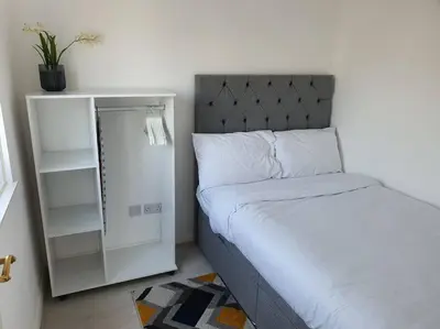 a small bedroom with a bed and a white cabinet at Awave From It All - Escape the city life in Jaywick Sands