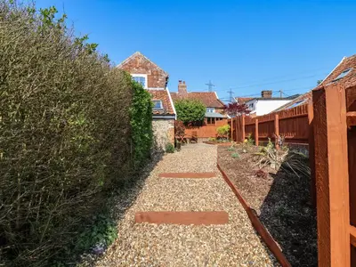 a garden with a gravel path in front of a house at Admiral Cottage in Woodbridge