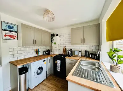 a kitchen with a sink and a washing machine at Deluxe Apartment in Southend-On-Sea by Artisan Stays I Free Parking I Sleeps 5 in Southend-on-Sea