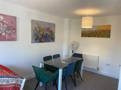 a dining room with a table and chairs and paintings at Warm & Cosy Homely 4 BDR Chesterton House w High Speed WIFI, Big Garden & Free Parking in Cambridge