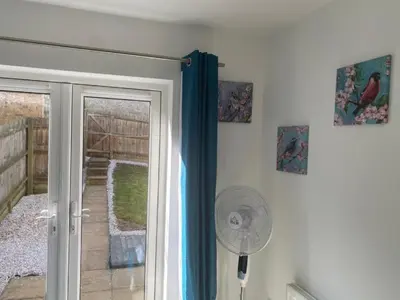 a fan next to a door with a window at Warm & Cosy Homely 4 BDR Chesterton House w High Speed WIFI, Big Garden & Free Parking in Cambridge