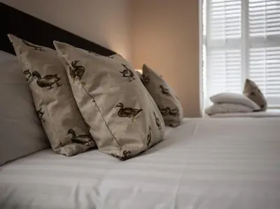 a bed with pillows with birds on it at Bridge Hotel Brandon in Brandon