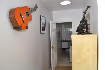 two guitars hanging on a wall in a room at Beautiful studio in Ely in Ely