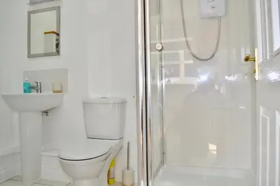 a white bathroom with a toilet and a shower at Beautiful studio in Ely in Ely