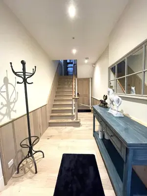 a living room with a table and a staircase at Moulton Lawn House B&B in Moulton