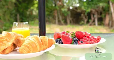 two plates of fruit and croissants and a glass of orange juice at 4-5 Bedroom House Garden Lots of Parking 15 min to city Close to motorway in Girton