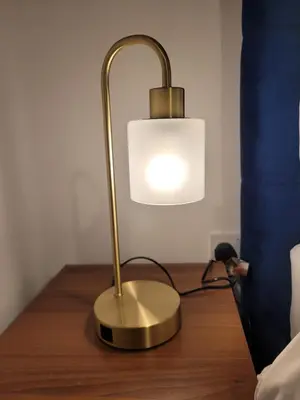 a gold lamp sitting on a table next to a bed at Kensington House- The Perfect home for contractor stays in Colchester