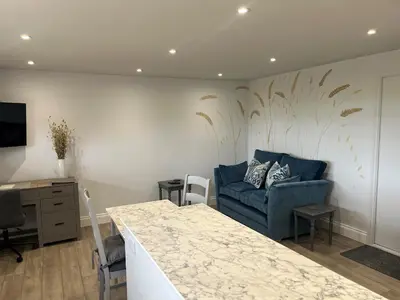 a living room with a blue couch and a table at The Retreat Field View in Little Maplestead