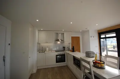 a kitchen with white cabinets and a counter top at The Retreat Field View in Little Maplestead