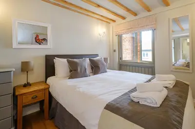 a bedroom with a large white bed and a window at Alde Bay Farm - Lobster Pot in Aldeburgh
