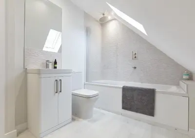 a white bathroom with a toilet and a bath tub at The Lodge Bury St Edmunds in Bury Saint Edmunds