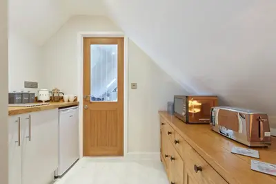 a kitchen with a microwave on top of a counter at The Lodge Bury St Edmunds in Bury Saint Edmunds