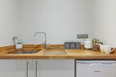 a kitchen with a wooden counter top with a sink at The Lodge Bury St Edmunds in Bury Saint Edmunds