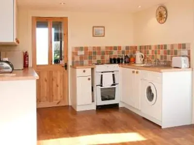 a kitchen with white cabinets and a washer and dryer at Paddock Barn ~ Short & Long term stay, pets welcome ~ Woodbridge, Framlingham ar in Cretingham