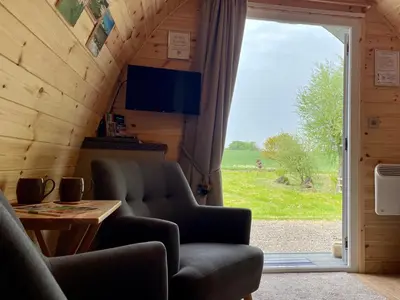 a living room with a large sliding glass door at Waterpump Pod for 2 adults with ensuite in the Suffolk Countryside in Badingham