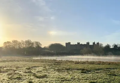 a foggy field with a castle in the background at Waterpump Pod for 2 adults with ensuite in the Suffolk Countryside in Badingham