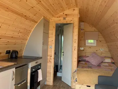 a small bedroom in a log cabin with a small bed at Waterpump Pod for 2 adults with ensuite in the Suffolk Countryside in Badingham