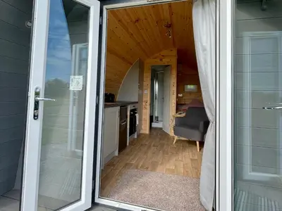 a door leading to a kitchen and a room at Waterpump Pod for 2 adults with ensuite in the Suffolk Countryside in Badingham