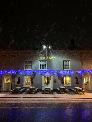 a building with tables in front of it at night at Swan Hotel by Greene King Inns in Thaxted