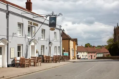 a street with tables and chairs outside of a building at Swan Hotel by Greene King Inns in Thaxted