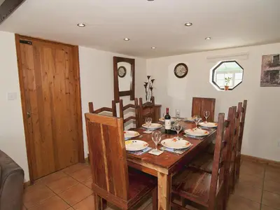 a dining room with a wooden table and chairs at St Andrews Barn in Necton