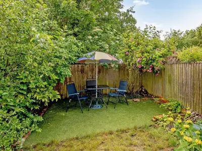 a backyard with a table and chairs and an umbrella at The Old Bike Shop in Brockdish