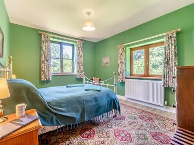a bedroom with green walls and a bed in it at St Mary's Chapel in New Buckenham