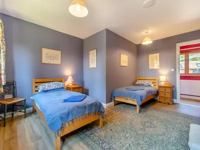 two beds in a room with blue walls at St Mary's Chapel in New Buckenham