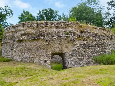 an old stone wall on top of a field at St Mary's Chapel in New Buckenham